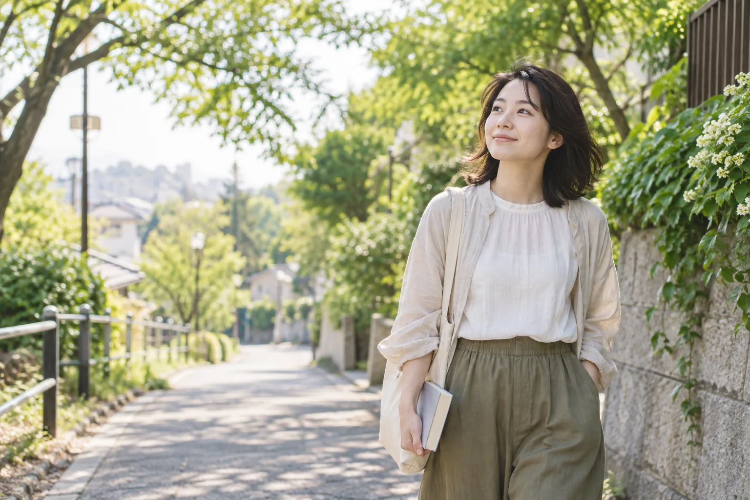 緑のある街を散歩する女性