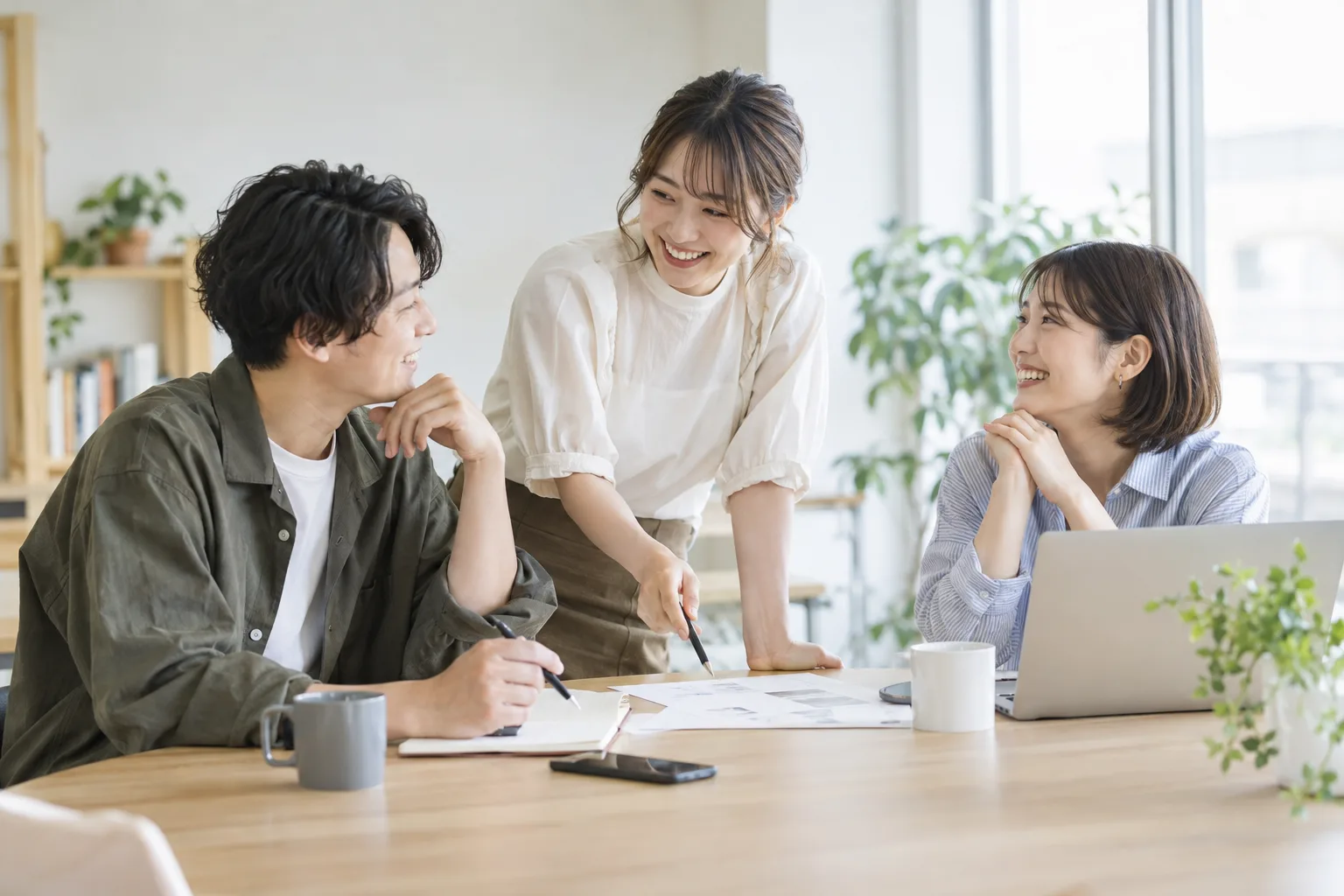 テーブルを囲んで仕事のアイデアを話し合う仲間たち