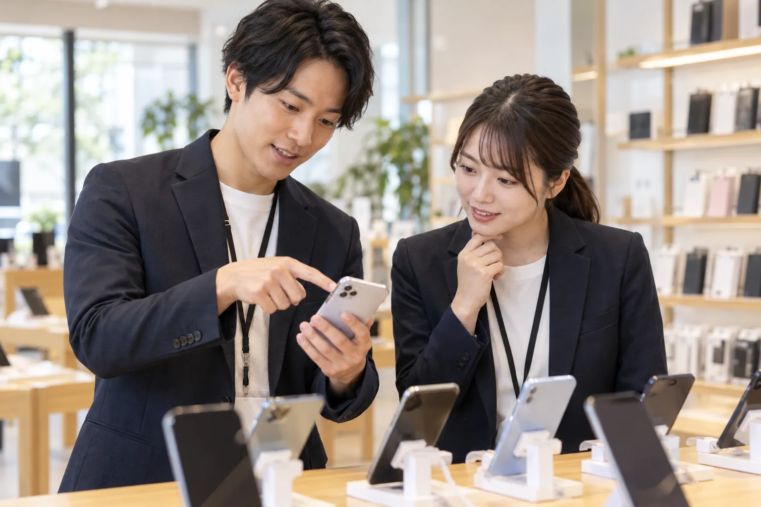 携帯販売の仕事を先輩から学ぶスタッフ